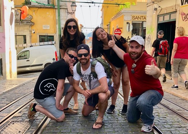 Collègues d'une équipe de développement web posant lors d'un voyage d'équipe à Lisbonne